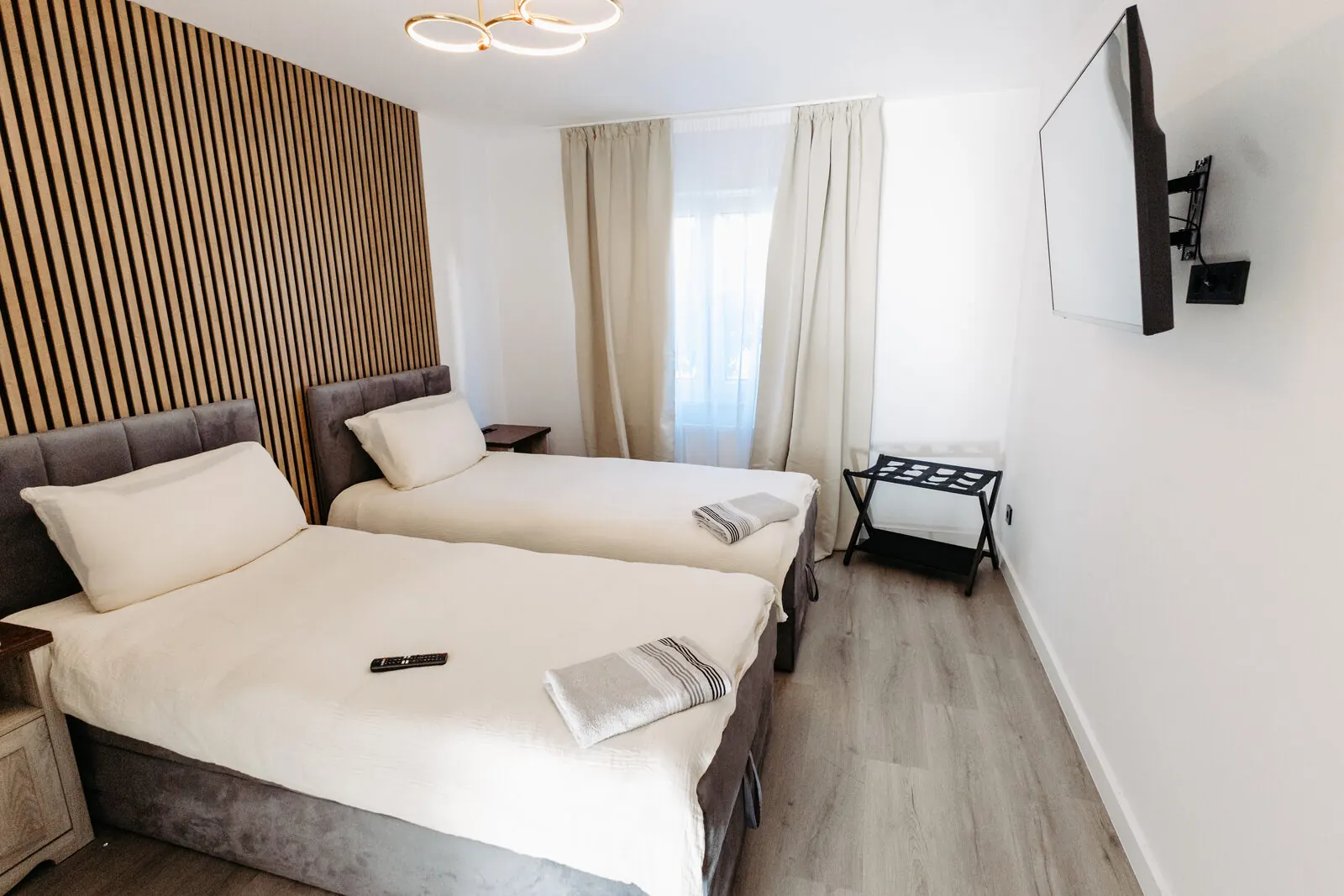 Schlafzimmer mit zwei bezogenen Betten und bereitgelegten Handtüchern